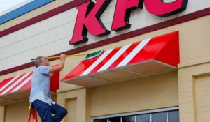 Mike uses a soft-bristled brush to clean an awning for KFC.